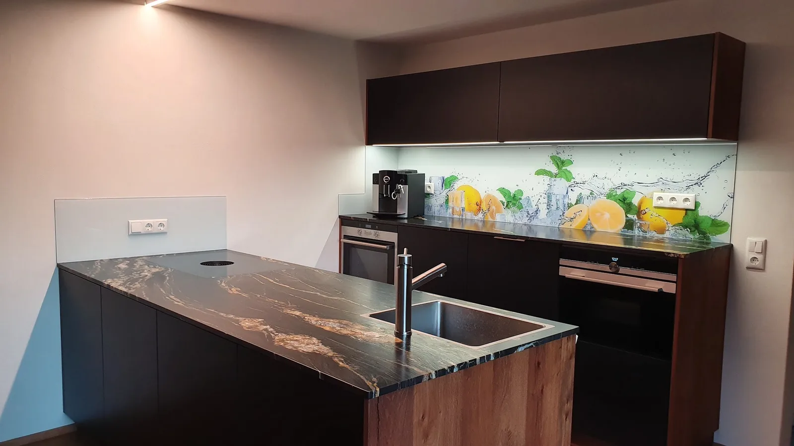 Küche mit einer bedruckten Glasrückwand zwischen Arbeitsplatte und Oberschränken