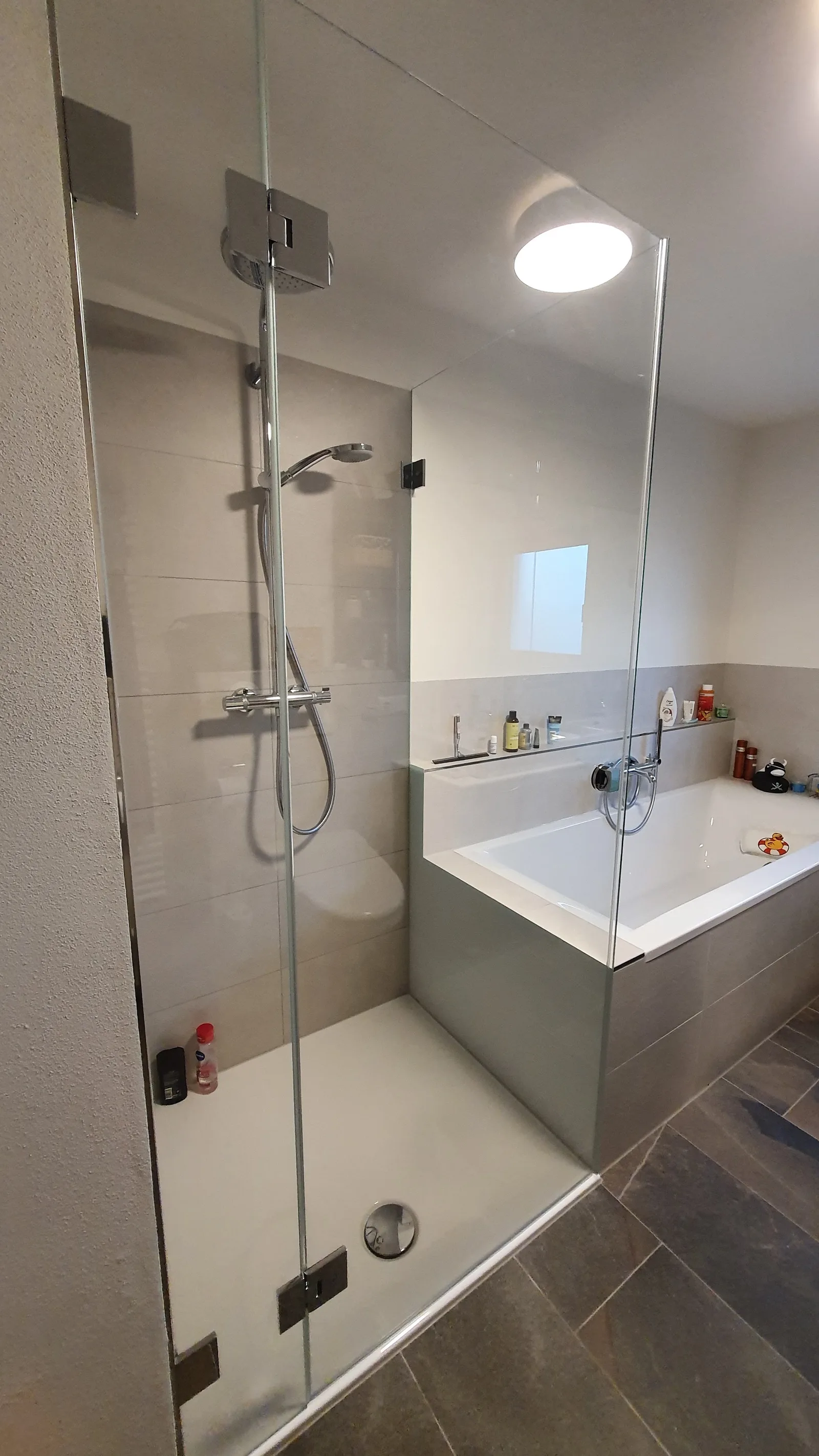 Glasdusche und Badewannenabtrennung in einem Badezimmer